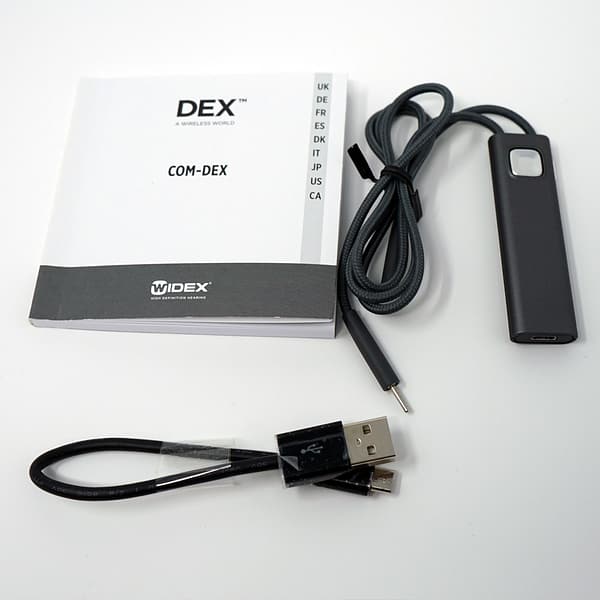 Dark grey widex alongside manual and USB cable