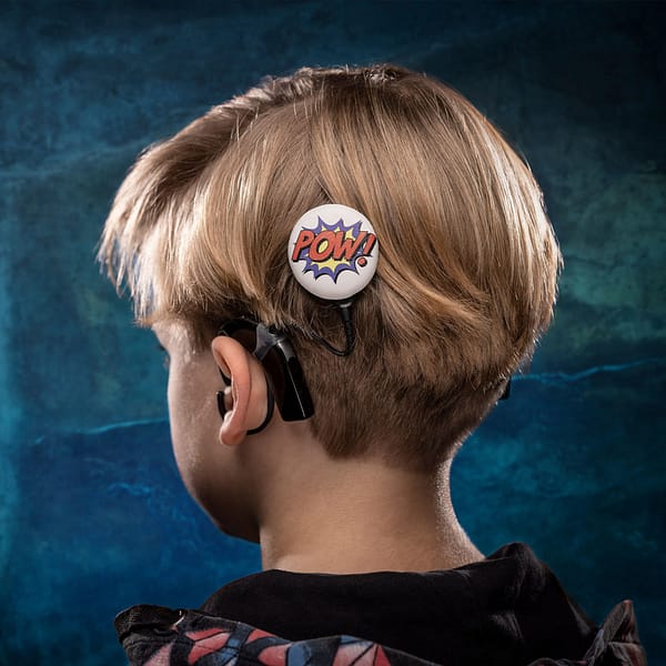 Little boy wearing the pow deesign hearing aid accessory from deafmetal