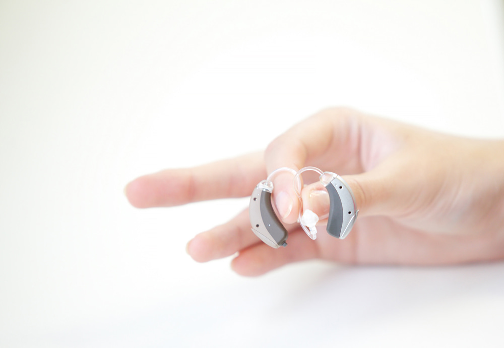 Female hand holding hearing aids