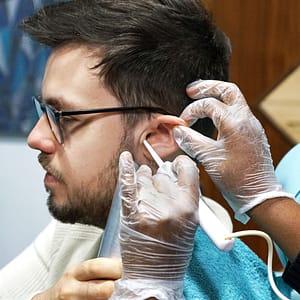 Brown-haired male having earwax removal by water irrigation