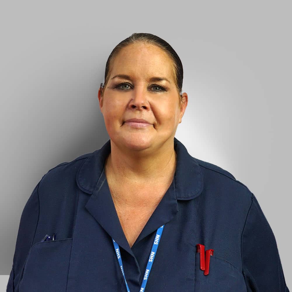 Photograph of Hearing Care Assistant Nurse (Donna) in Navy uniform with NHS lanyard