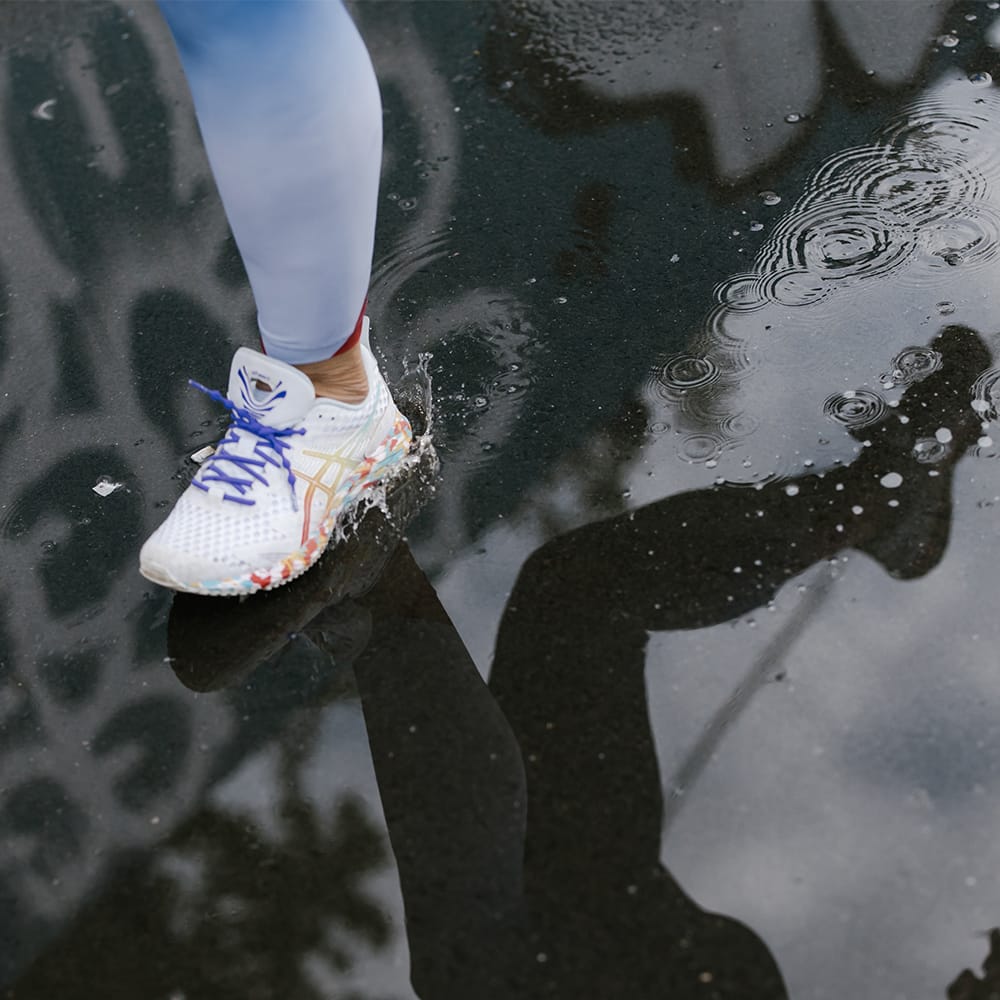 Up close of the leg of a woman jogging in the rain