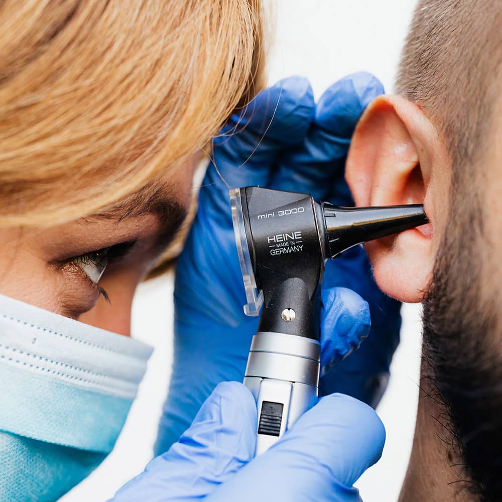 Audiologist performing an ear check up using otoscope