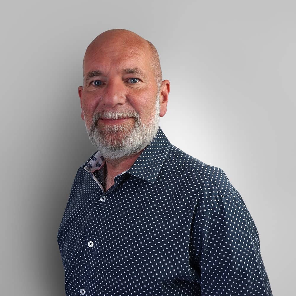 Photograph of Hear4U CEO Ben Bennett wearing checkered dark blue shirt with silver beard