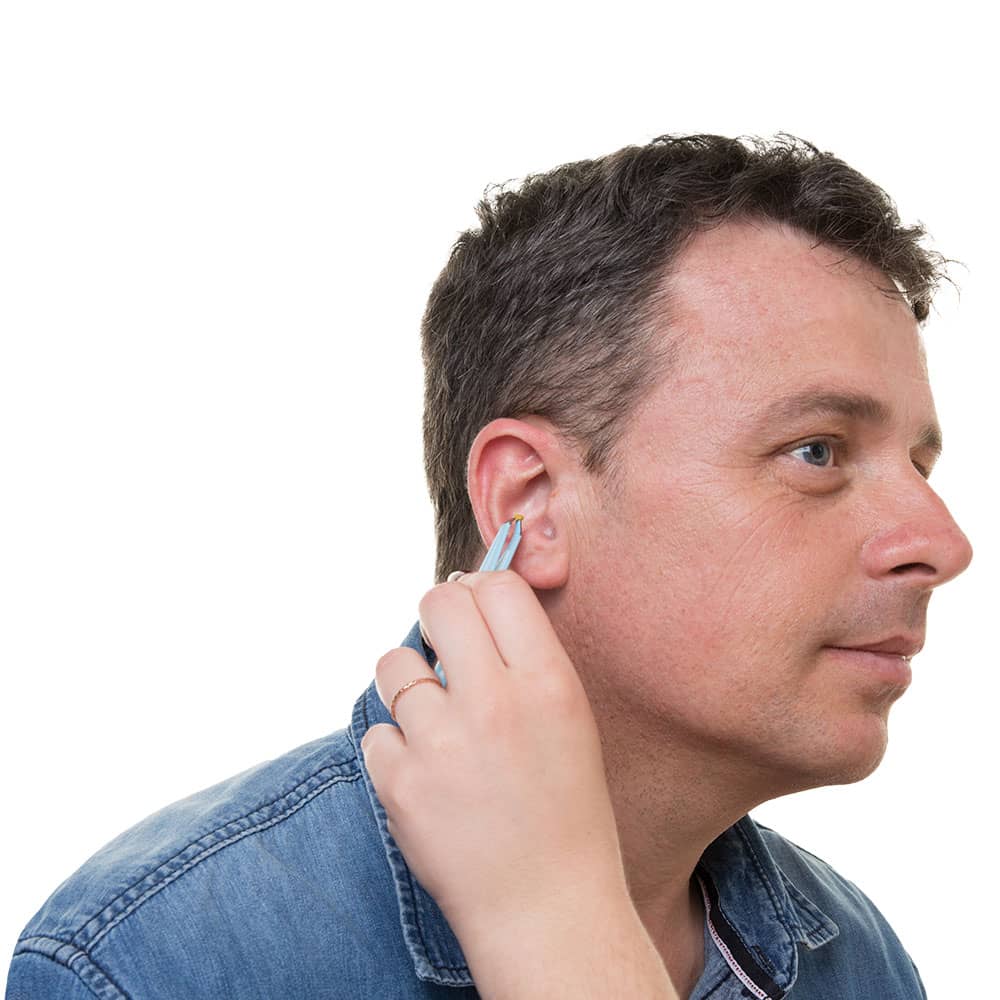 Middle aged man getting a manual ear wax removal from a audiologist