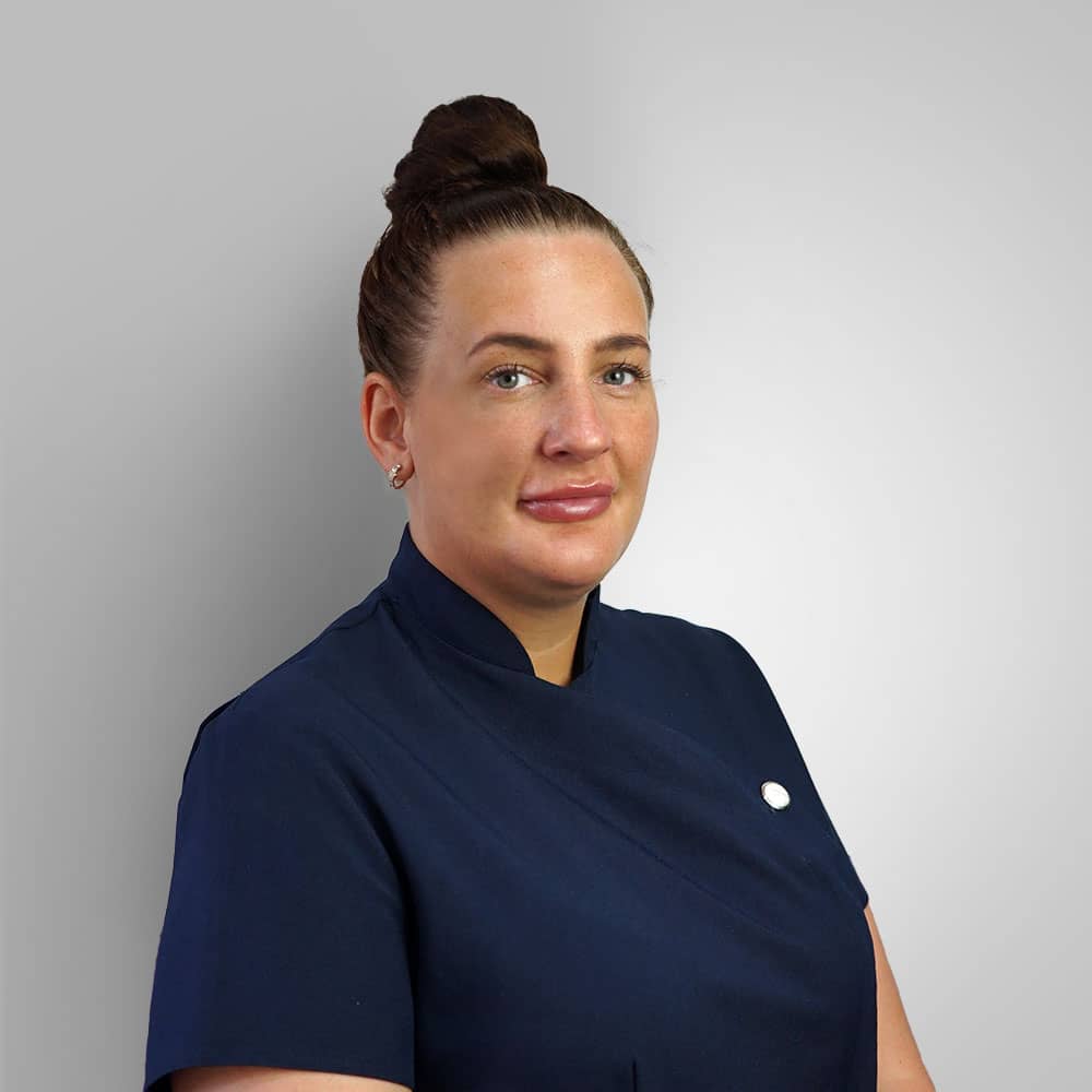 Photograph of female receptionist (Rebecca) in navy uniform with dark hair in a bun