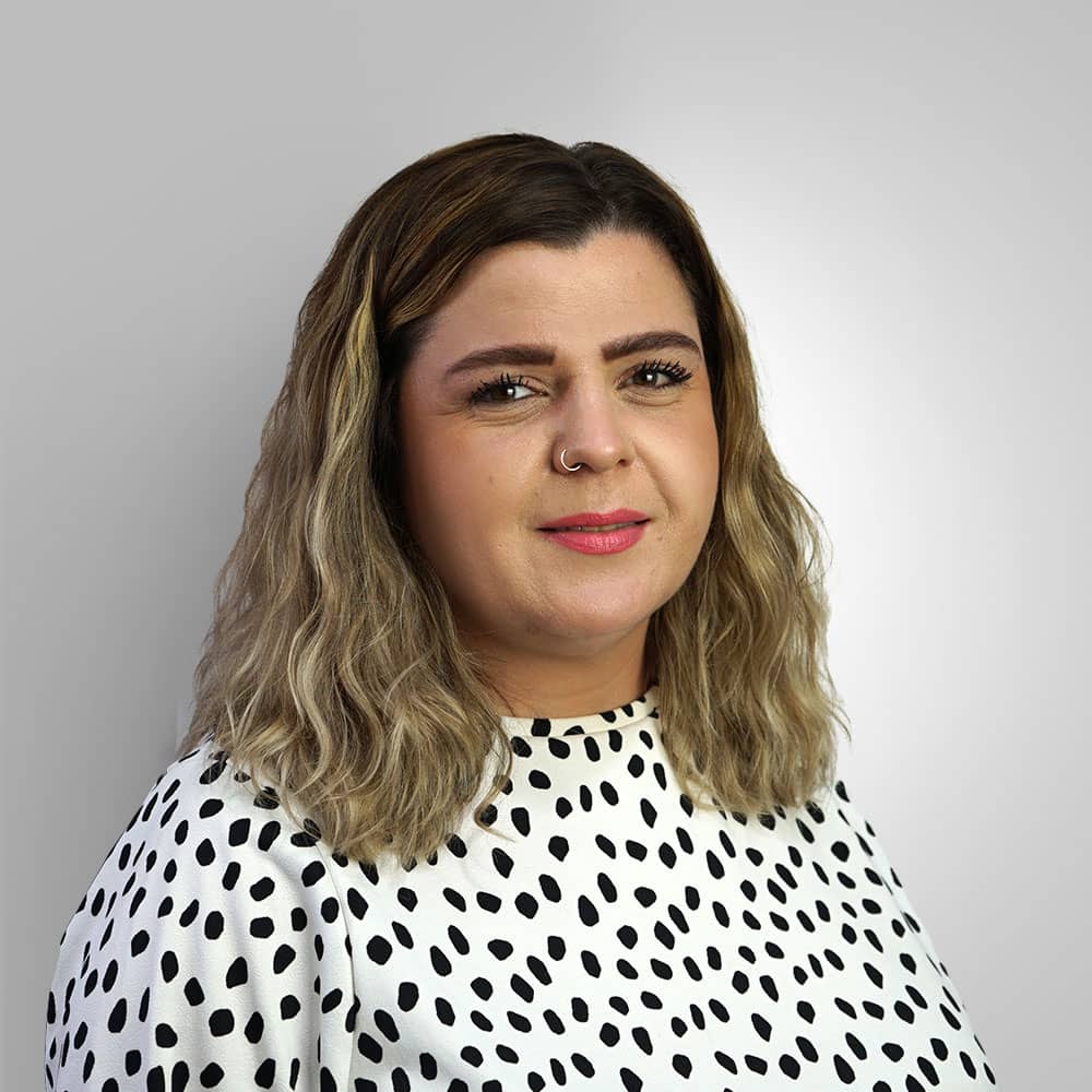 Photograph of Hear4U Business Development Manager Emma wearing white shirt with black polkadots, with ombre hair and a beautiful smile