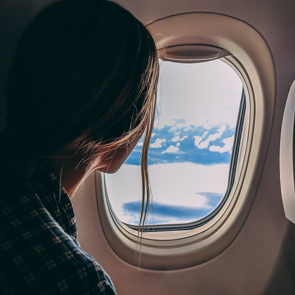 Woman on a plane looking out window