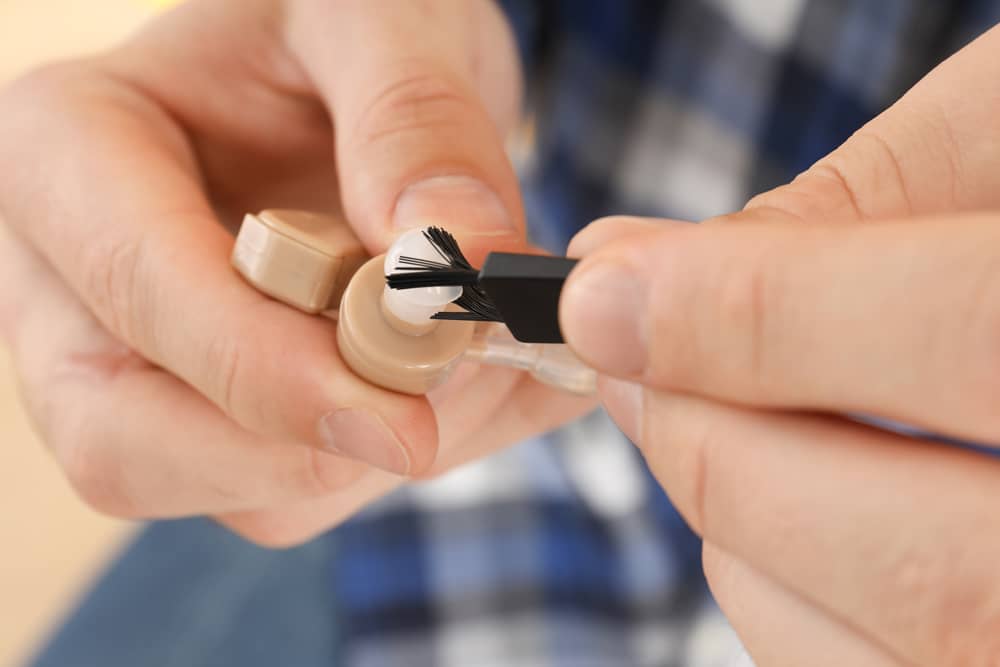 Closeup of person cleaning a hearing aid
