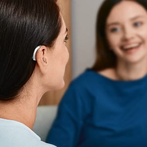Woman wearing hearing aid having conversation with friend