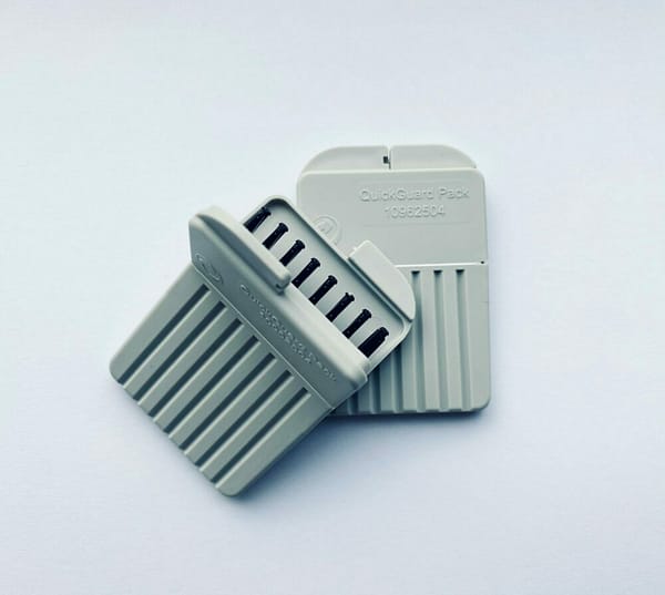 Two Connexx wax guards on a white background with one open pack ontop of another